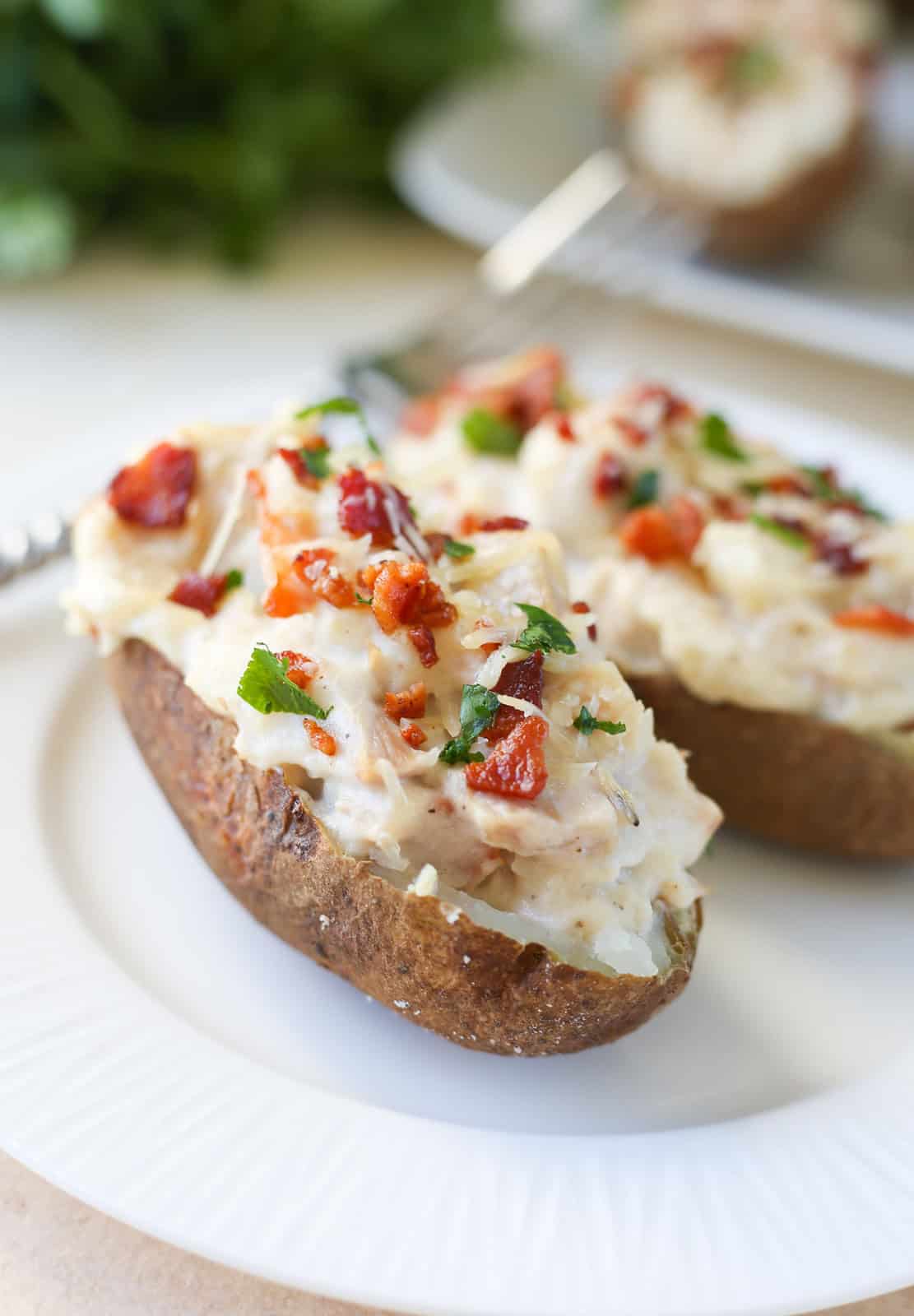 Classic twice baked potatoes with a twist! Chicken Alfredo Twice Baked Potatoes are filled with chicken, alfredo sauce, bacon, and Parmesan cheese! Just 5 ingredients. 
