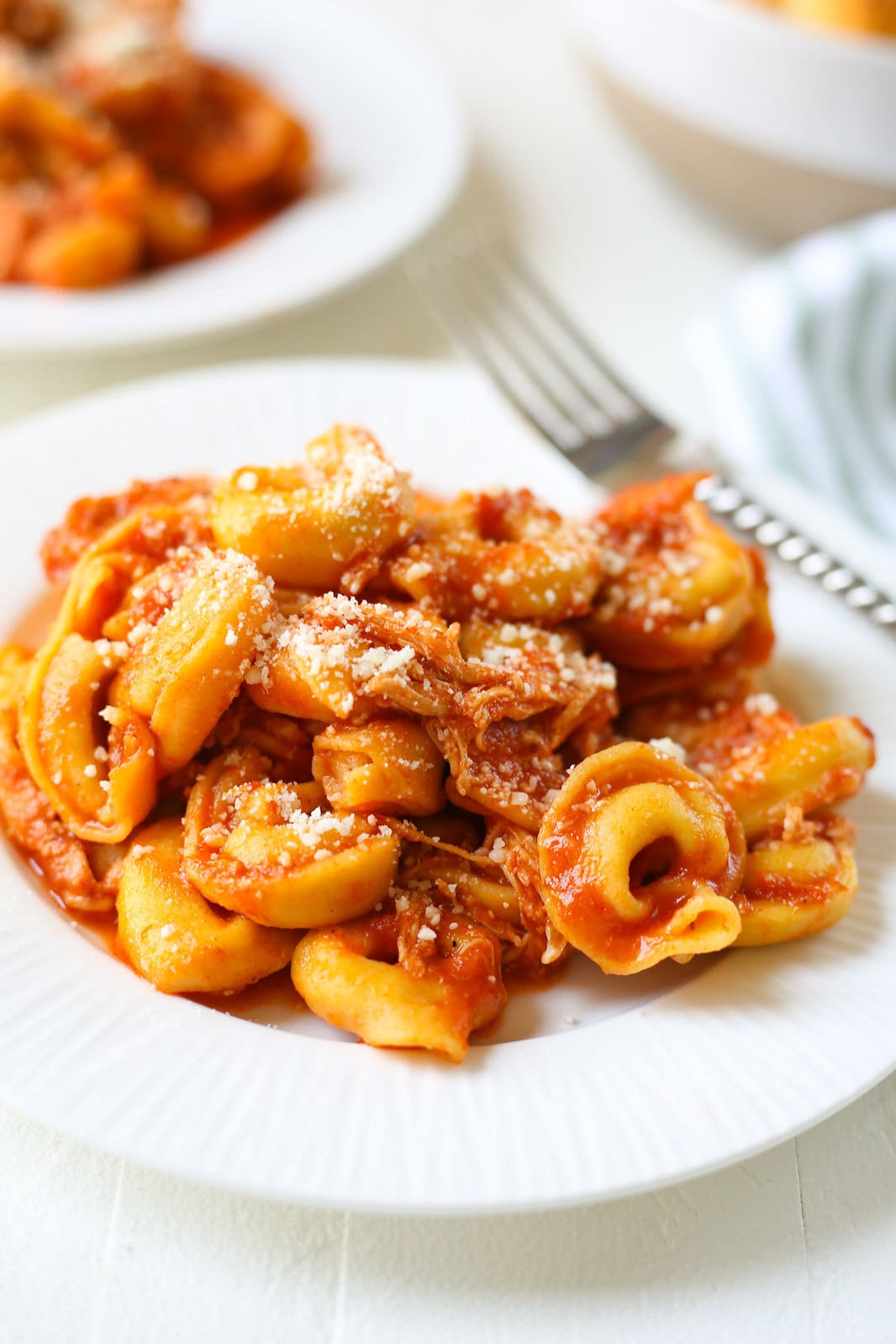 Slow Cooker Chicken Parmesan Tortellini is going to be your new favorite no fuss dinner recipe! Chicken and cheese tortellini in a cheesy pasta sauce, all cooked in the crockpot.