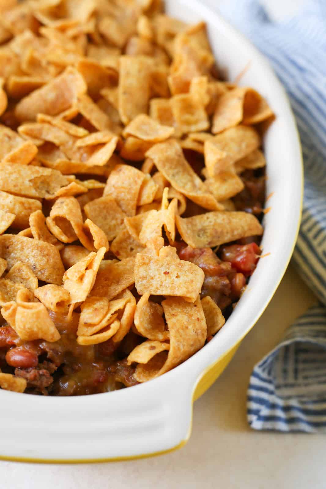 walking taco casserole topped with Fritos in a casserole dish