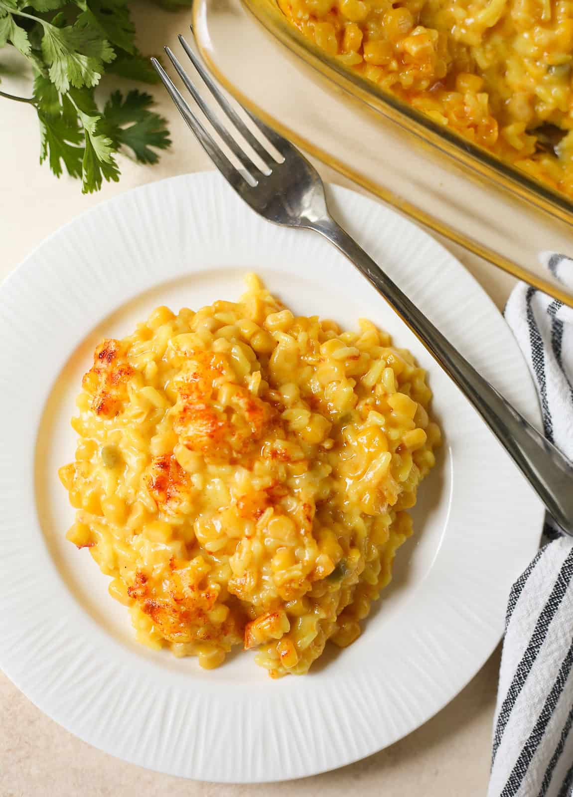 overhead shot of cheesy corn casserole with yellow rice