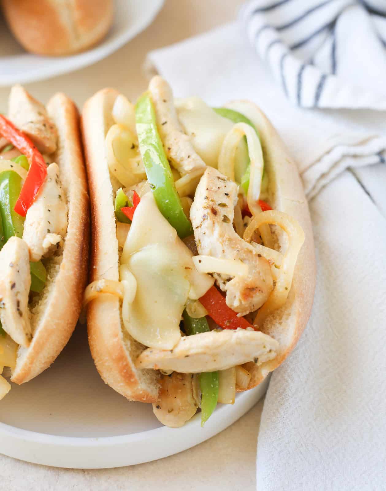 Chicken Cheesesteaks are a quick but flavorful dinner that the whole family will love. Thinly sliced chicken, onion, and bell pepper stuffed in a sub roll and covered in melted provolone cheese. They're ready in less than 30 minutes!