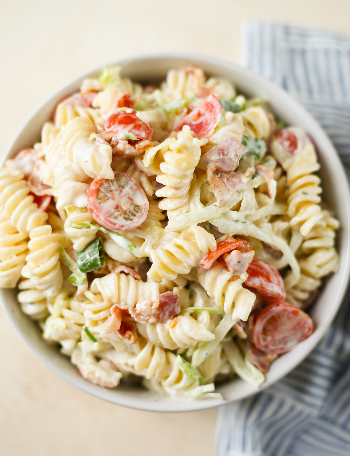 overhead shot of pasta salad with bacon, tomatoes, green onions, and lettuce with ranch dressing